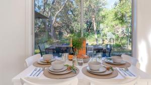 a dining room with a table and a large window at Kangaroo Cottage in Currarong