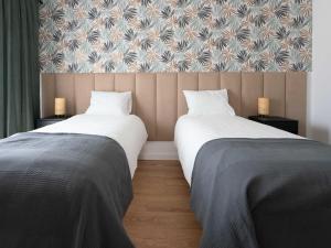 two beds sitting next to each other in a room at Aparthotel Weissa 7 in Krakow