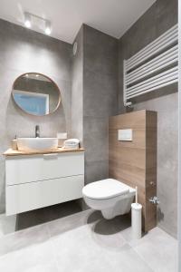W łazience znajduje się toaleta, umywalka i lustro. w obiekcie Aparthotel Weissa 7 w Krakowie