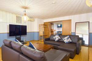 a living room with a couch and a tv at Haneda Lex Apartment in Tokyo