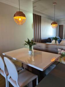 a dining room with a table and chairs and a couch at Aconchegante Apartamento decorado e mobiliado in Cascavel