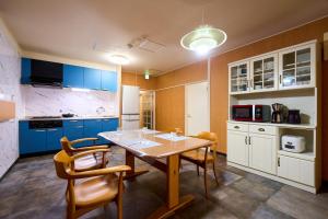 a kitchen with blue cabinets and a table and chairs at Haneda Lex Apartment in Tokyo