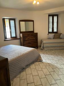 een slaapkamer met 2 bedden, een dressoir en een spiegel bij UN PASSO DAL CASTELLO in Barolo