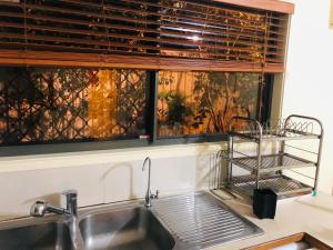 a kitchen sink with a window and a drying rack at Aspley property in Brisbane