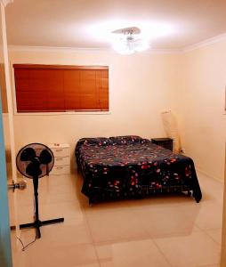 a bedroom with a bed and a fan in it at Aspley property in Brisbane