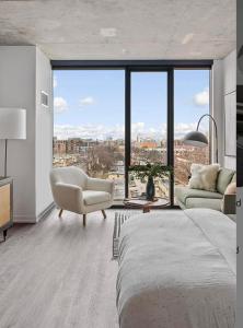 - une chambre avec un lit, une chaise et une grande fenêtre dans l'établissement Brand New Luxe Convertible Studio/Downtown views, à Chicago