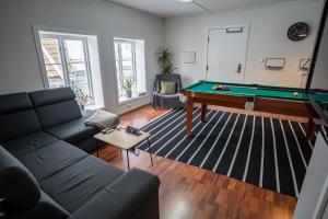a living room with a couch and a pool table at In Heart of Stavanger BnB with Billiard & Sauna in Stavanger