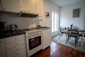 a kitchen with a stove and a table in it at In Heart of Stavanger BnB with Billiard & Sauna in Stavanger