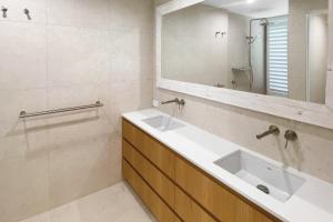 un bagno con due lavandini e uno specchio di The Cove Noosa - Apartment 18 a Noosa Heads Altre 6 foto