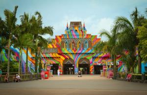 a colorful building with palm trees in front of it at Pousada Morada dos ANJOS in Penha