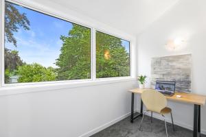 an office with a desk and two windows at Papawai Townhouse #11 in Rotorua