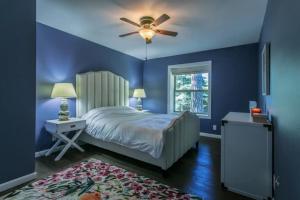 Modern Open Concept Mountain View NEW Home في جبل شاستا: غرفة نوم زرقاء مع سرير ومروحة سقف