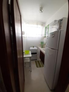 uma cozinha com um frigorífico branco e uma mesa em Fonte da Serra em Teresópolis