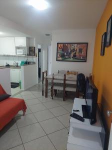 sala de estar con mesa y cocina en Apartamento na Praia dos Anjos, en Arraial do Cabo