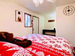 Un dormitorio con una cama roja con un osito de peluche. en Cozy Spa Retreat Near Resorts and Snow Play, en Big Bear City