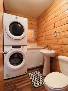y baño con lavadora y aseo. en Cozy Spa Retreat Near Resorts and Snow Play, en Big Bear City