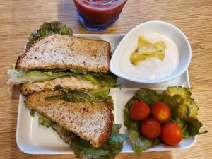 a sandwich and a plate with a salad and a drink at Kuganipi Beachside Inn Iriomote in Iriomote
