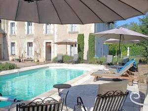 einen Pool mit 2 Stühlen und einem Sonnenschirm in der Unterkunft Gîte Arfeuilles, 4 pièces, 6 personnes - FR-1-489-436 in Arfeuilles