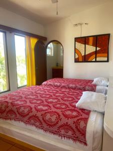 - une chambre avec un lit et une couette rouge dans l'établissement El Palmar Beach Tennis Resort, à San Patricio - Melaque