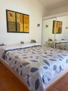 a large bed in a room with two windows at El Palmar Beach Tennis Resort in San Patricio Melaque