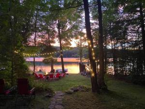 un gruppo di tavoli e sedie di fronte a un lago di Dawson Loop Inn 3BR Lakefront Chalet Style Cottage a Maynooth