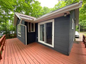 una casa con terrazza in legno e finestra di Dawson Loop Inn 3BR Lakefront Chalet Style Cottage a Maynooth