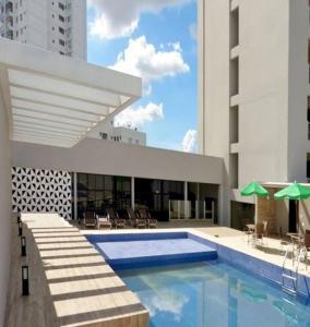 a building with a swimming pool in front of a building at Flat Bristol 911 in Goiânia