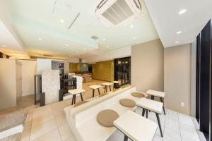 a room with tables and chairs and a heater at Fourz Hotel Kintetsu Osaka-Namba in Osaka