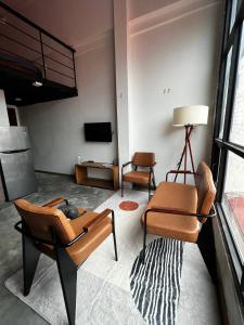 a living room with several chairs and a television at liora Cambodia - Riverside Loft Apartments in Phnom Penh