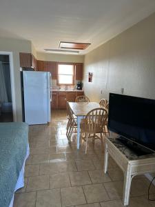 ein Wohnzimmer mit einem Tisch und einem Kühlschrank in der Unterkunft Cape Hatteras Motel in Buxton