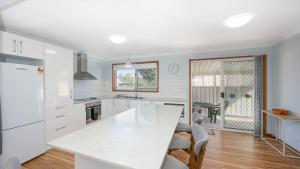 a kitchen with white cabinets and a white counter top at Waratah in Iluka