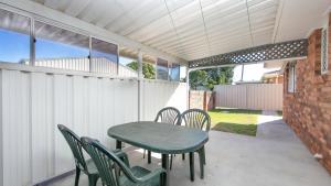 a patio with a table and chairs and a brick wall at Waratah in Iluka