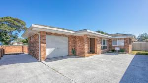 a brick house with a garage at Waratah in Iluka