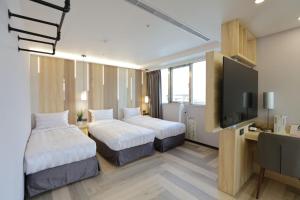 台北的住宿－新凱商務飯店，酒店客房设有两张床和一台平面电视。