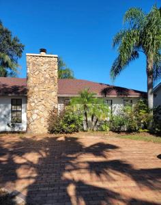 a stone house with a palm tree in front of it at Florida Oasis in Auburndale