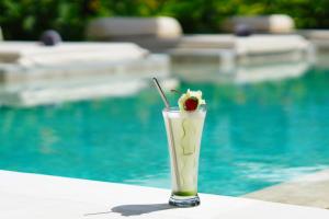een drankje met een kers bovenop naast een zwembad bij Amazing Lombok Resort in Selong Belanak