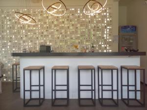 a bar with four stools in front of a counter at Amazing Lombok Resort in Selong Belanak