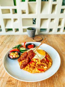 un plato de comida con huevos salchichas y verduras en una mesa en Amazing Lombok Resort en Silungbelanak