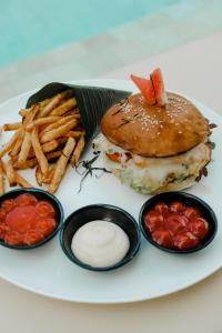 a plate of food with a sandwich and french fries at Amazing Lombok Resort in Selong Belanak