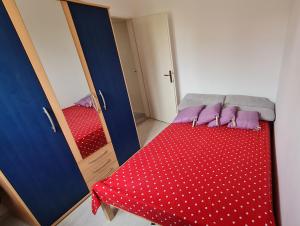 Habitación pequeña con cama roja y espejo. en House Maja en Jadrija