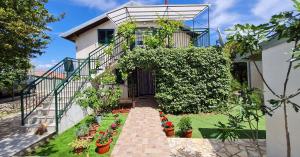 a house with a garden with potted plants at House Maja in Jadrija