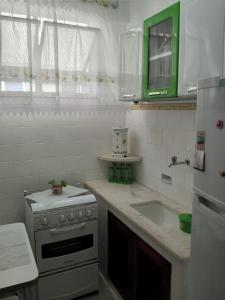 a white kitchen with a stove and a sink at Fonte da Serra in Teresópolis