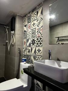 a bathroom with a sink and a toilet and a mirror at liora Cambodia - Riverside Loft Apartments in Phnom Penh