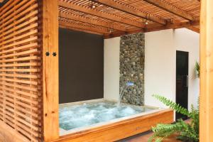 a jacuzzi tub in a house with a wooden frame at Visita Cuenca y quédate en Picota Cucho una encantadora quinta VIP con jacuzzi y turco a 10km del centro de la ciudad -16 huéspedes in Cuenca