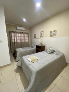 Un dormitorio con dos camas y una mesa y una ventana. en Monoambiente Centrico, en Santiago del Estero