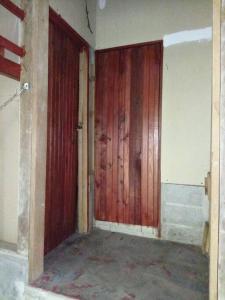 ein Zimmer mit zwei Holztüren in einem Haus in der Unterkunft Mi rincón en la montaña. in La Ceiba