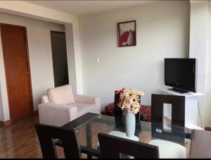 a living room with a glass table and a television at Departamento en el centro histórico in Ayacucho