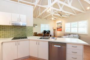 a kitchen with white cabinets and a sink at Seashells Broome in Broome