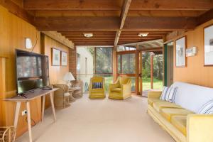 ein Wohnzimmer mit Couch und Flachbildfernseher in der Unterkunft Shearwater Beach House in Silverleaves in Cowes