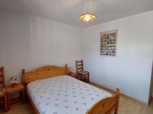 1 Schlafzimmer mit einem Holzbett und 2 Stühlen in der Unterkunft Appart 1 chambre au centre, 3éme étage, 6 pers, pied des pistes - FR-1-516-206 in Les Deux Alpes